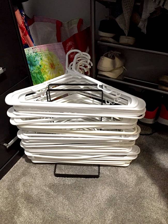 reviewer's hanger organizer with lots of white hangers on it