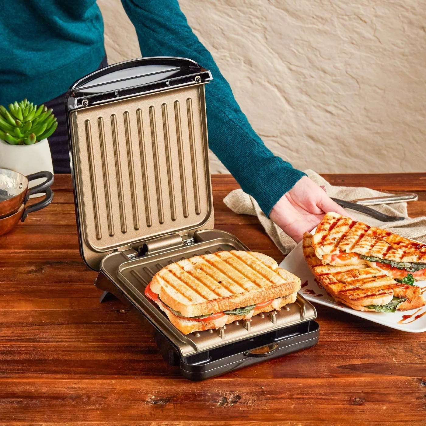 A model making a panini using the square-shaped grill
