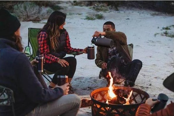 Models camping and using the growler at a campsite