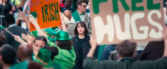 Alice walking down the street through a Saint Patrick's Day parade in "How To Be Single"