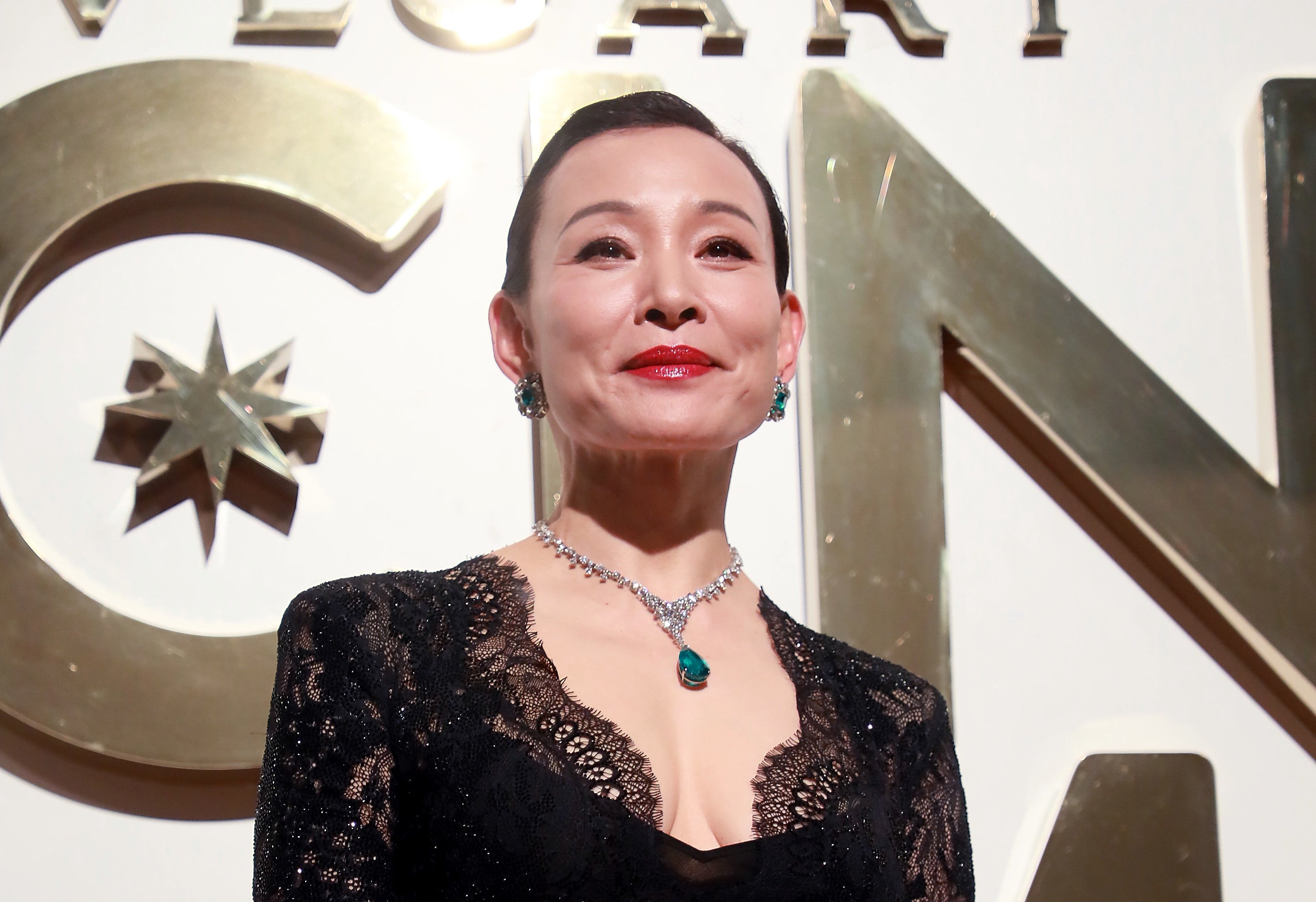 Joan Chen looking very regal in a lacy black outfit and bejeweled necklace