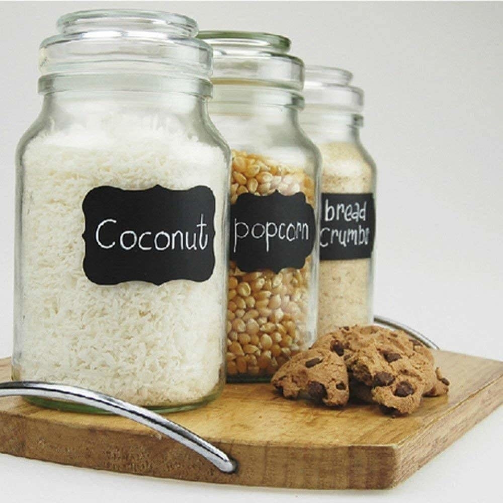 Jars of ingredients with labels on them next to cookies on a tray 