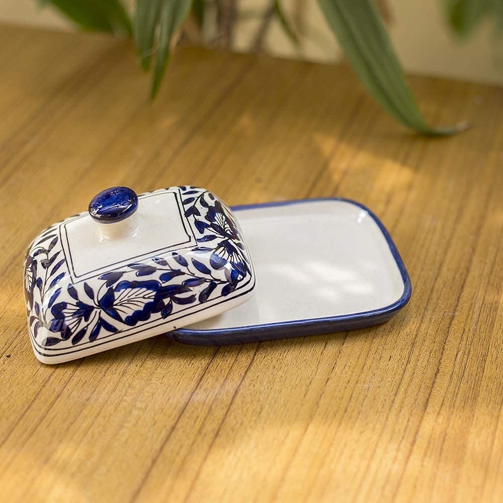 A blue and white ceramic butter dish on a table 