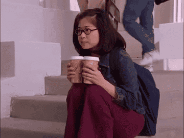 Lane Kim looks somber as she clutches two coffees on set of &quot;Gilmore Girls&quot;