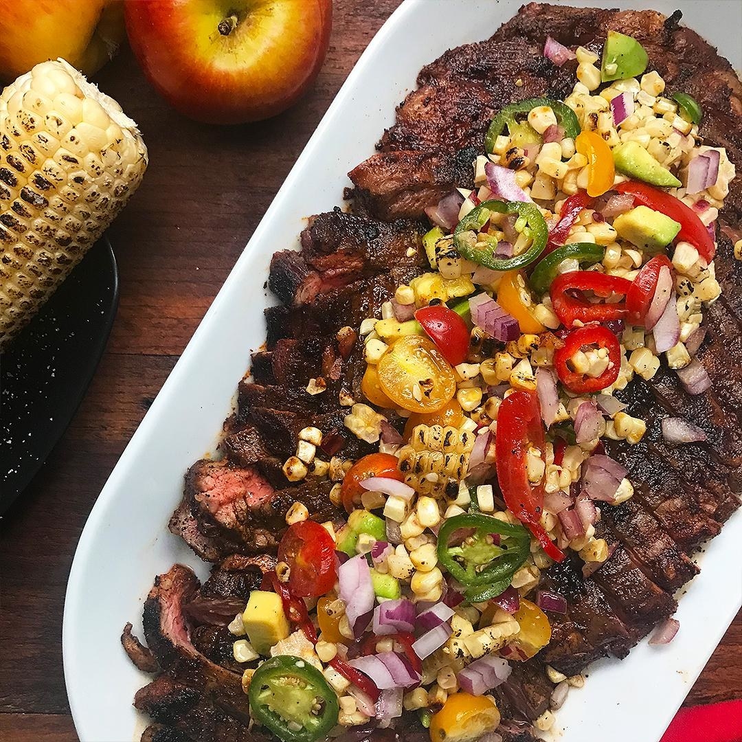 Flank steak topped with corn, tomato, jalapeño, onion, and peppers