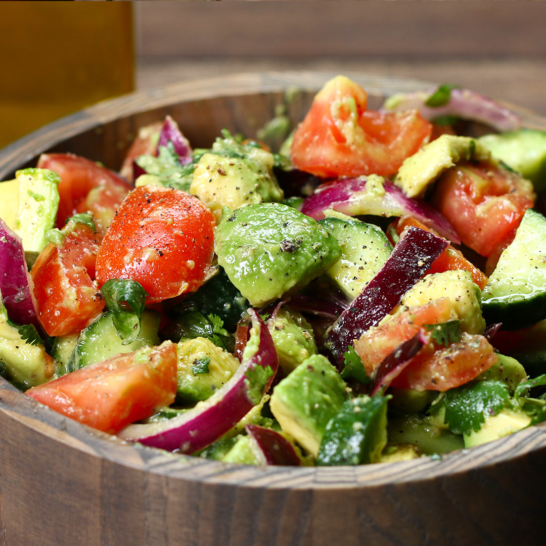 A bowl of tomato, avocado, and red onion salad