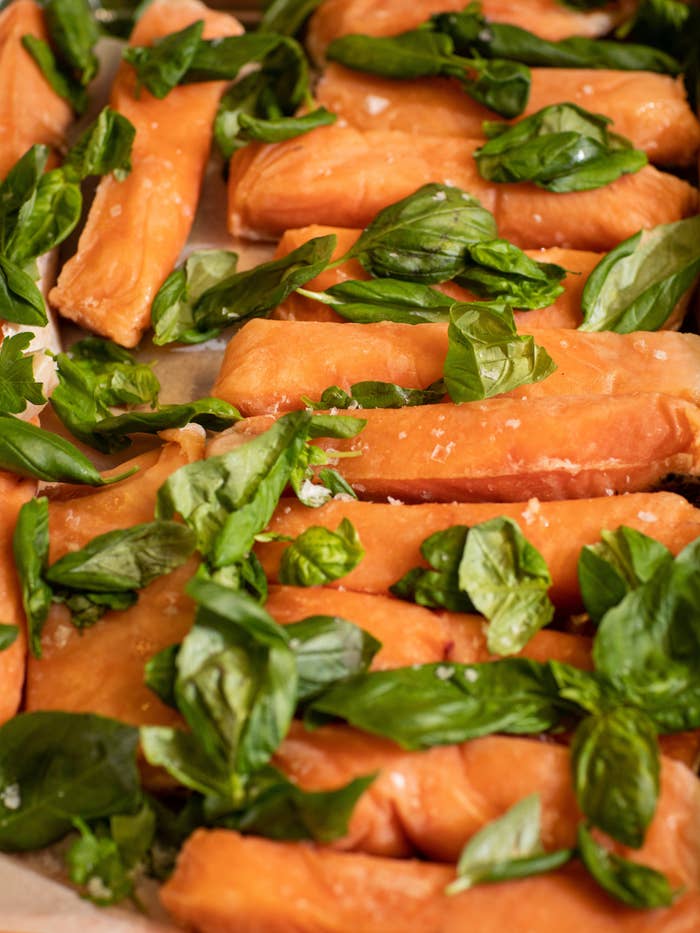 A pan of fish and greens waiting to be cooked.