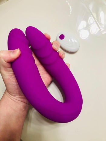 Model bending dildo with white remote in background