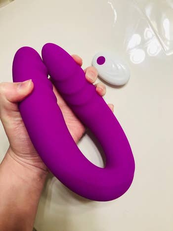 Model bending dildo with white remote in background
