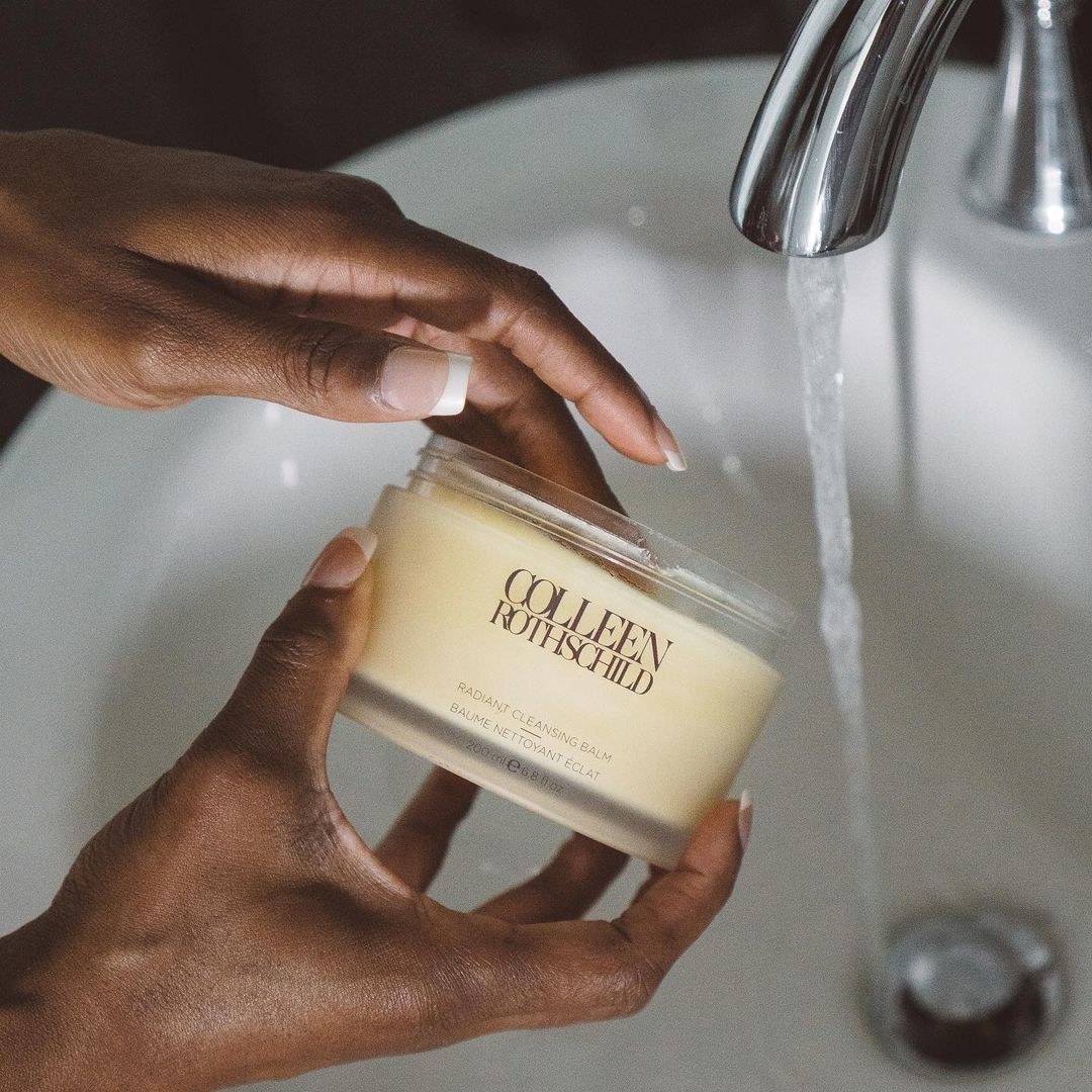 hands holding the jar of cleansing balm