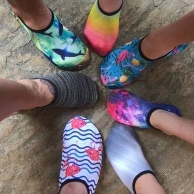 Reviewer's photo showing the whole family wearing the aqua socks in different prints
