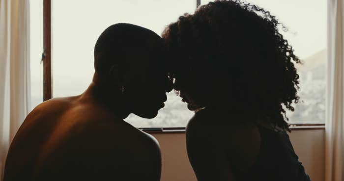 A backlit image of a couple with their foreheads touching