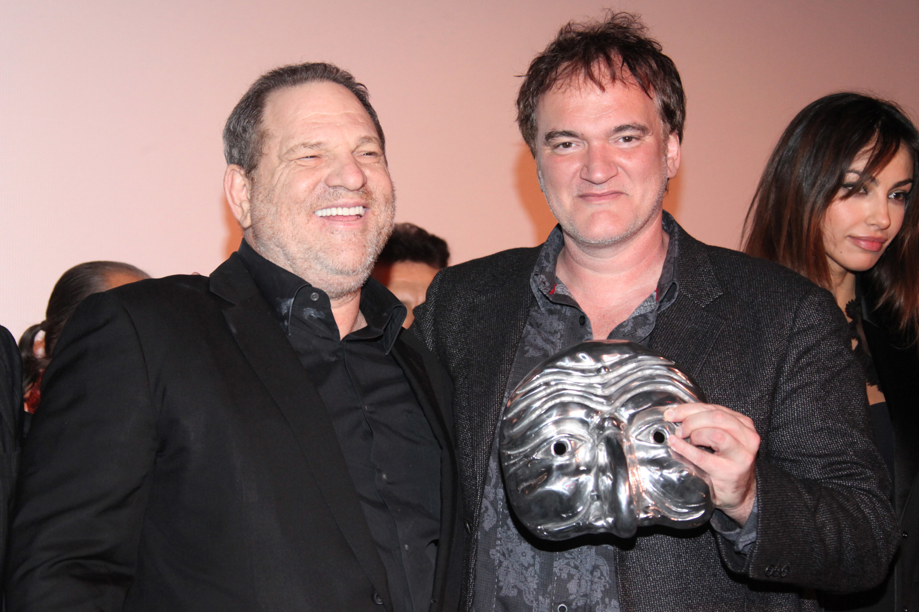 Tarantino holds a mask while standing next to Weinstein in 2013