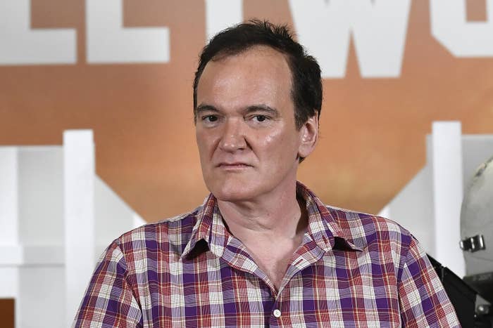 Quentin Tarantino wears a collared shirt while looking in the distance
