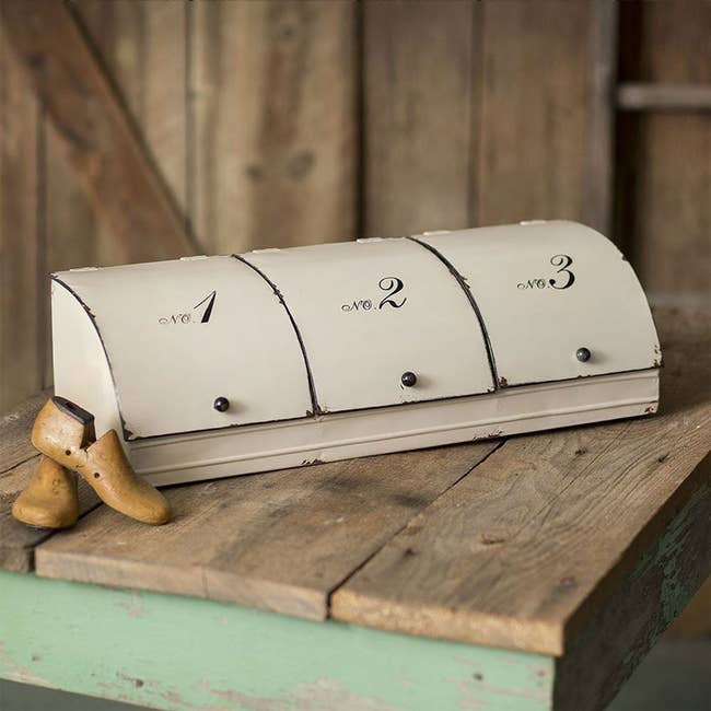 Rustic tin storage bin with each opening labeled with a number