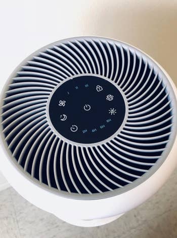 the top of a reviewer's air purifier with the different setting buttons 