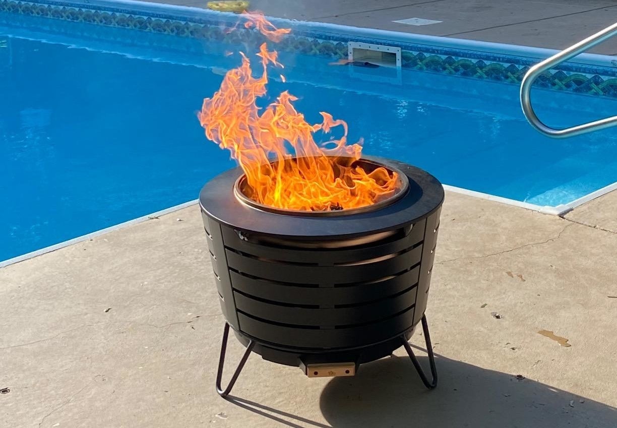 reviewer image of a lit tiki fire pit next to an in ground pool