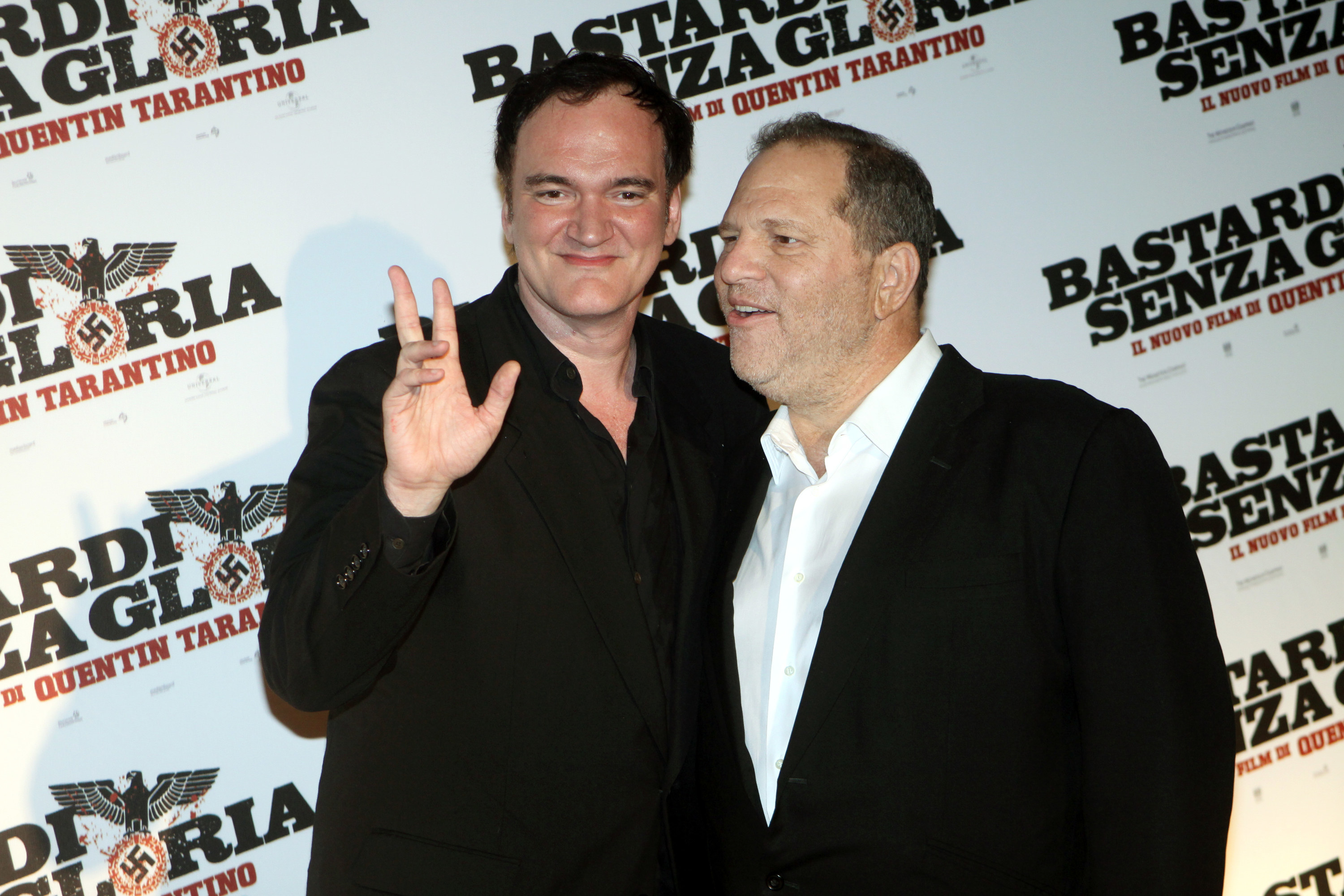 Tarantino waves to the camera with his arm around Weinstein in 2009