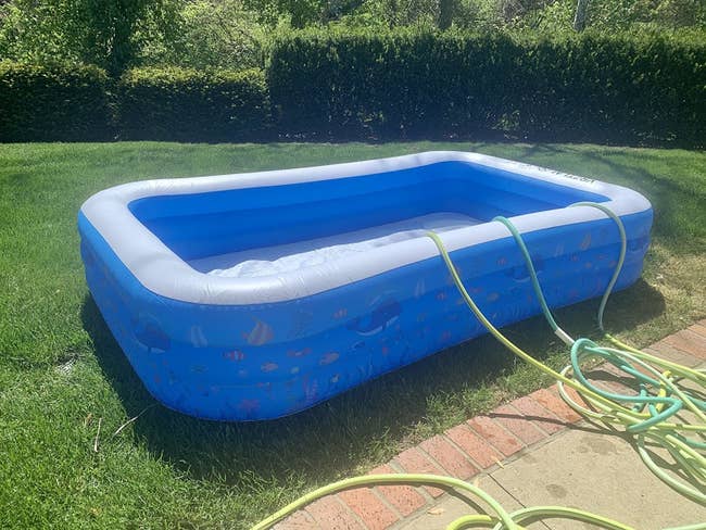 reviewer image of an inflated full-sized pool being filled with water from three hoses