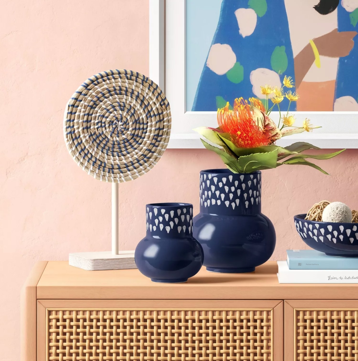 the two sized vases in navy blue with white dots on a cabinet