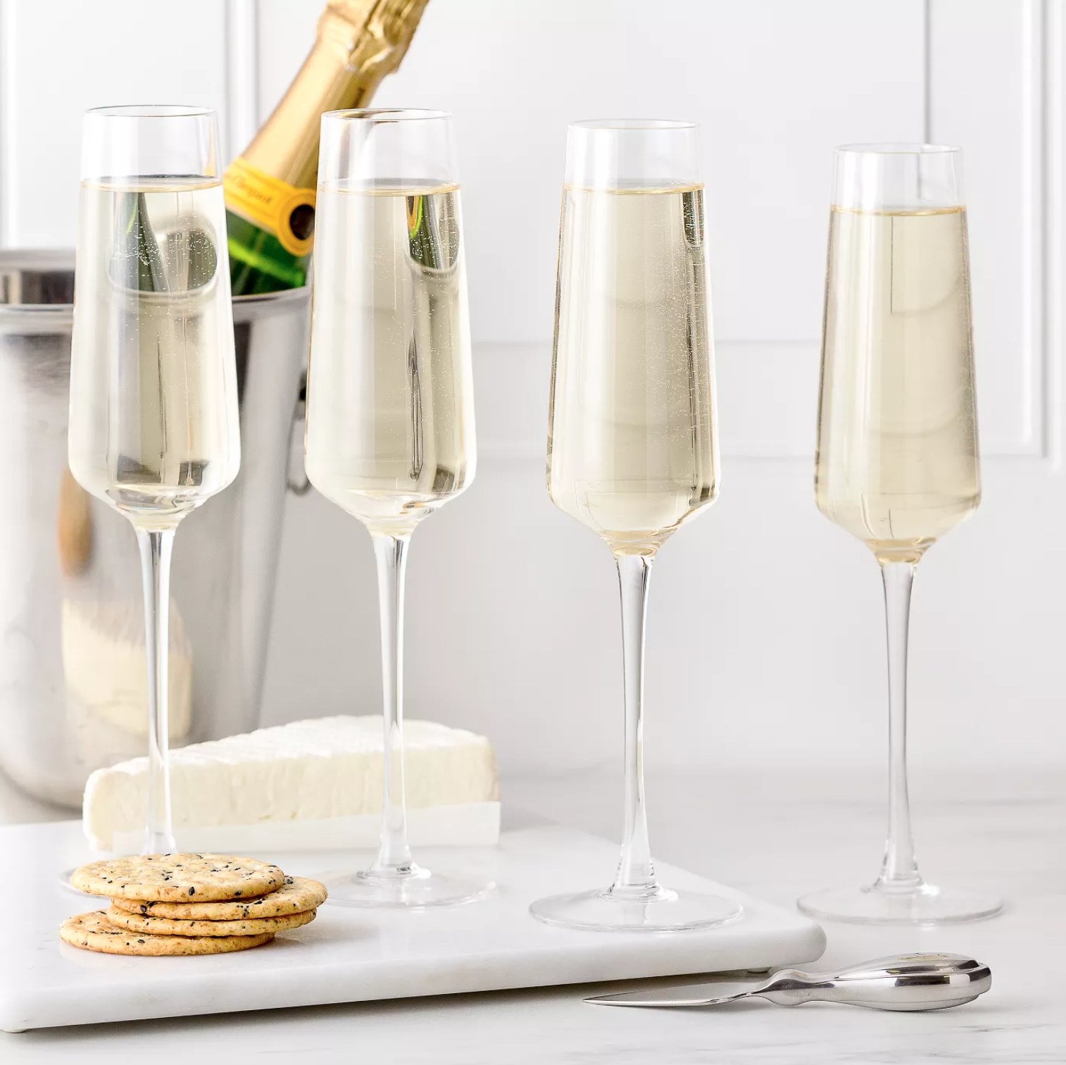 the set of flutes next to cheese and crackers