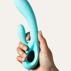 A hand holds a light blue rabbit vibrator