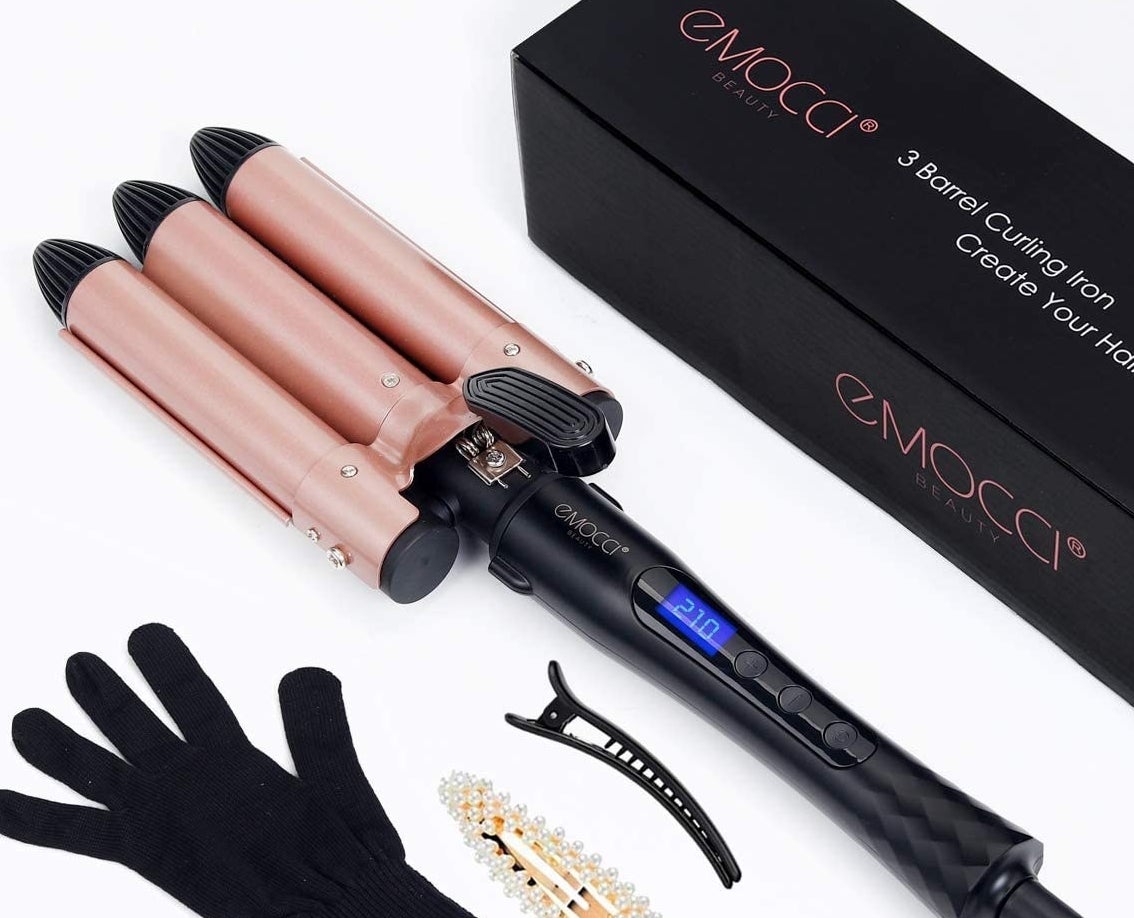 The triple barrel curling iron next to two clips and a heat resistant glove 