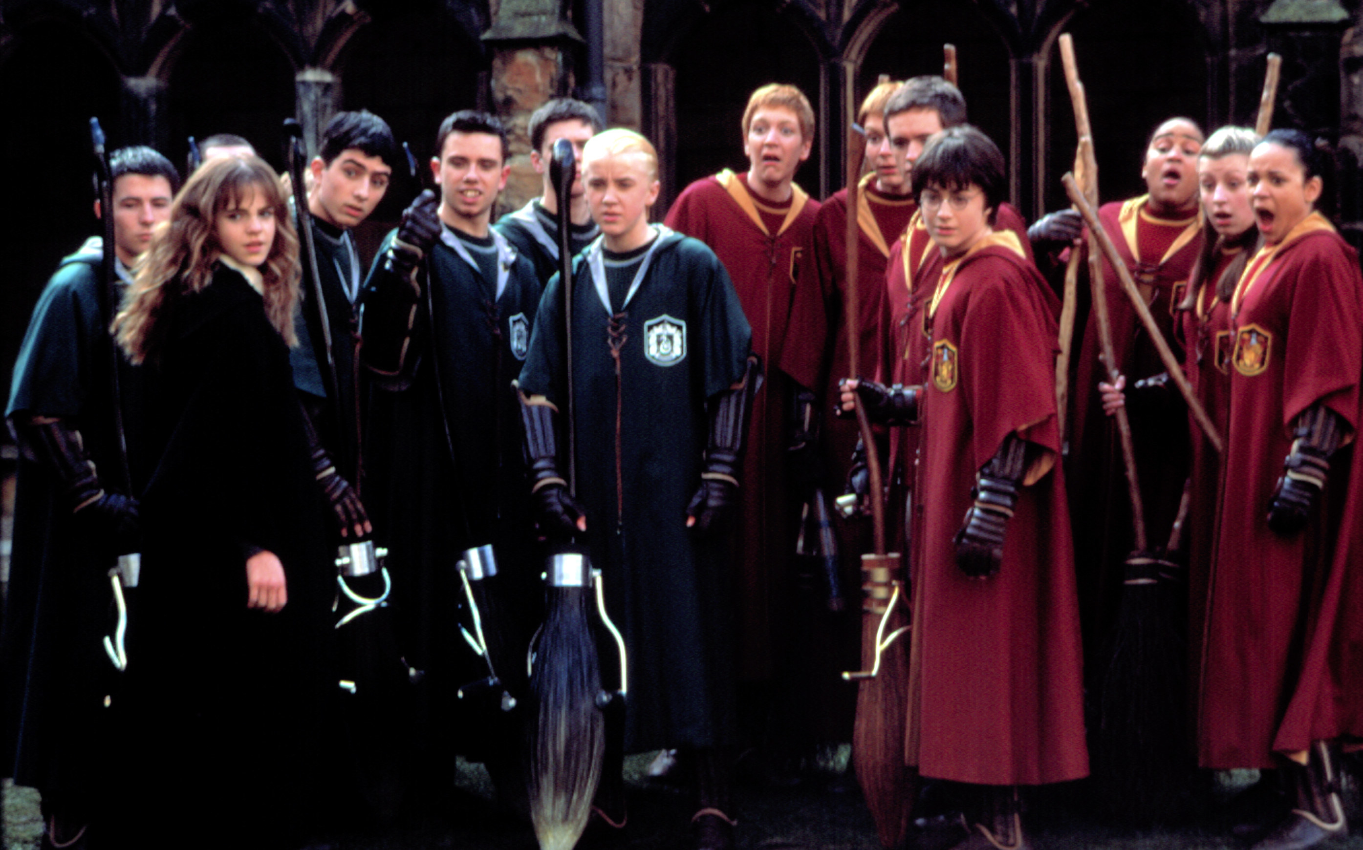 The cast of Harry Potter and the Chamber of Secrets brandishes their brooms