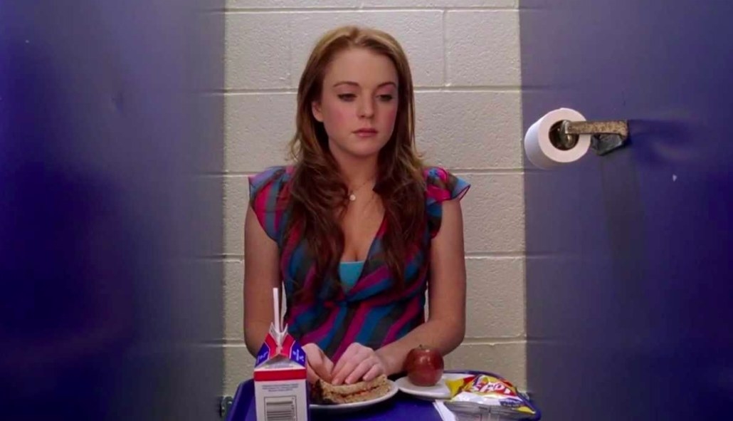 Cady sits on the toilet with her food tray in Mean Girls