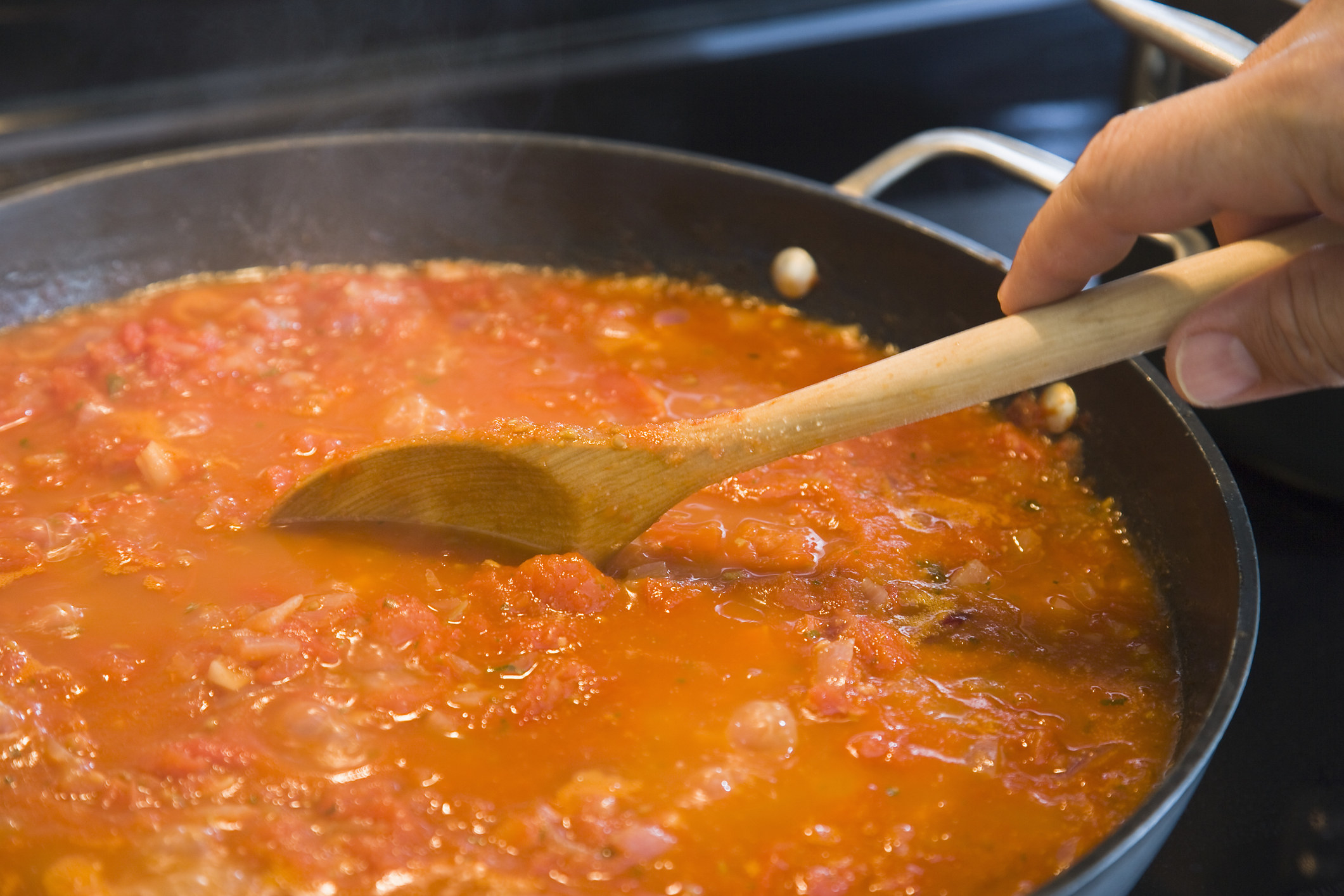 Stirring a pot of tomato sauce.