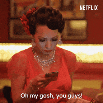 Woman wearing a big bow in her hair looks at her cellphone and says, &quot;Oh my gosh, you guys!&quot;