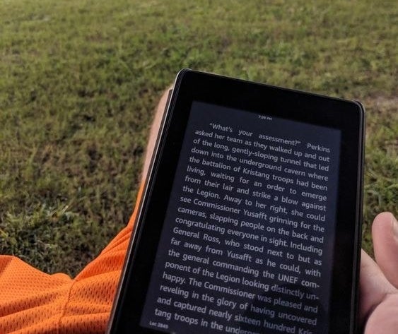 Reviewer holding the Kindle to read a book