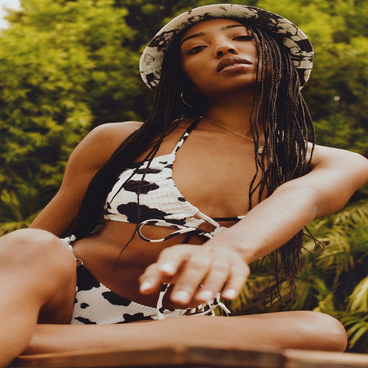 model wearing cow-print bucket hat, wearing cow-print bikini set