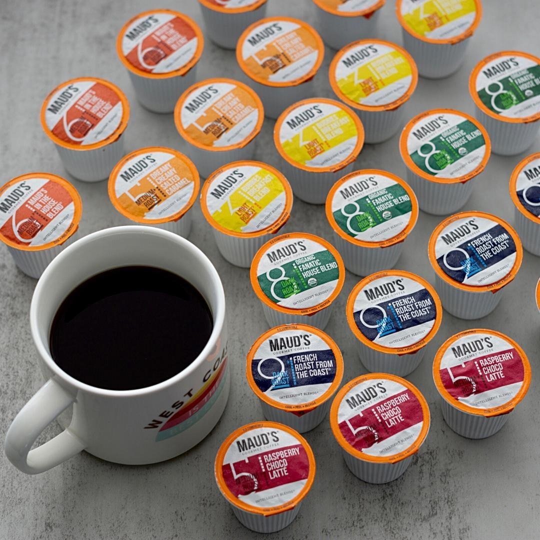 a coffee cup next to a bunch of maud&#x27;s coffee pods 