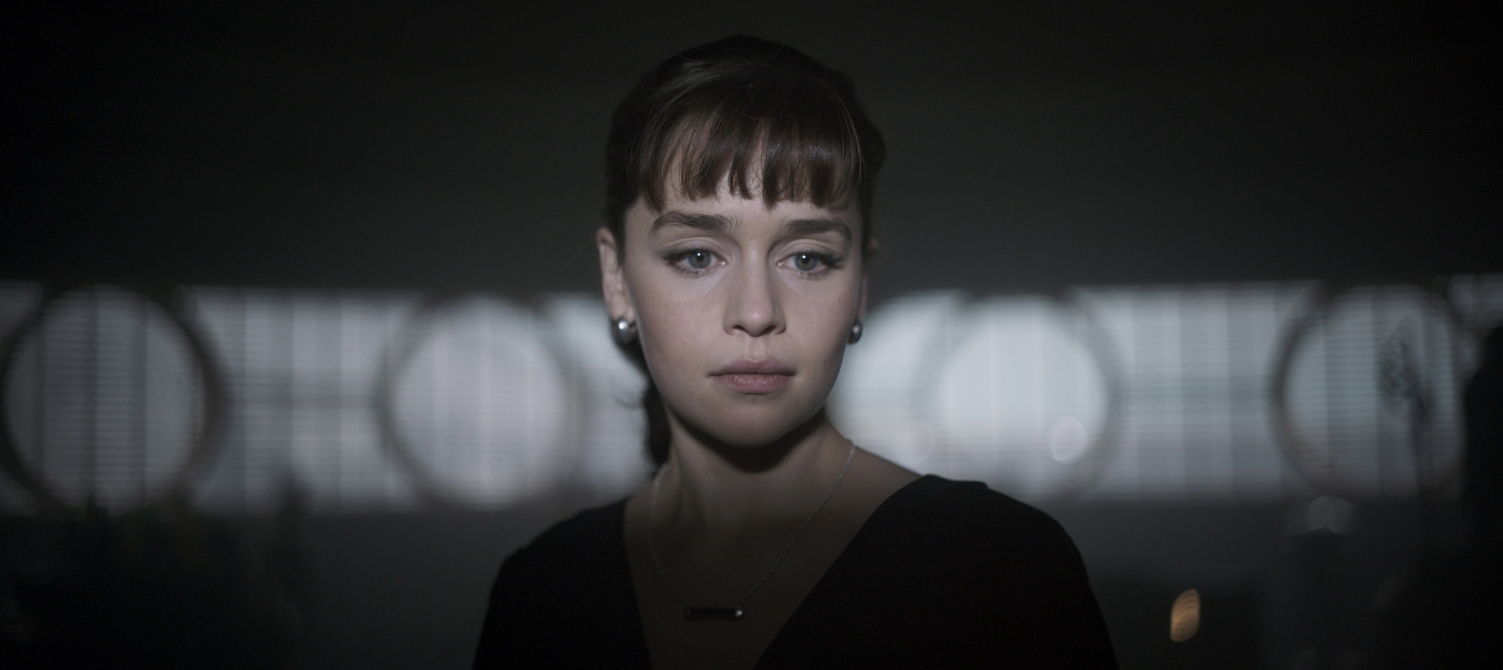 Emilia Clarke as Qi’ra, looking thoughtful, faces the camera but looks off to the left in &quot;Solo: A Star Wars Story&quot;