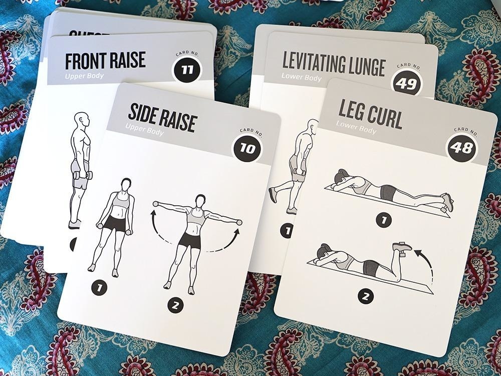 a reviewer photo of a few of the exercise cards showing how to do the leg curl and a side raise with a dumbbell