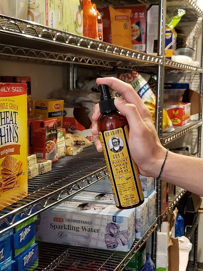 Person spraying shelves of packaged food in a grocery store 