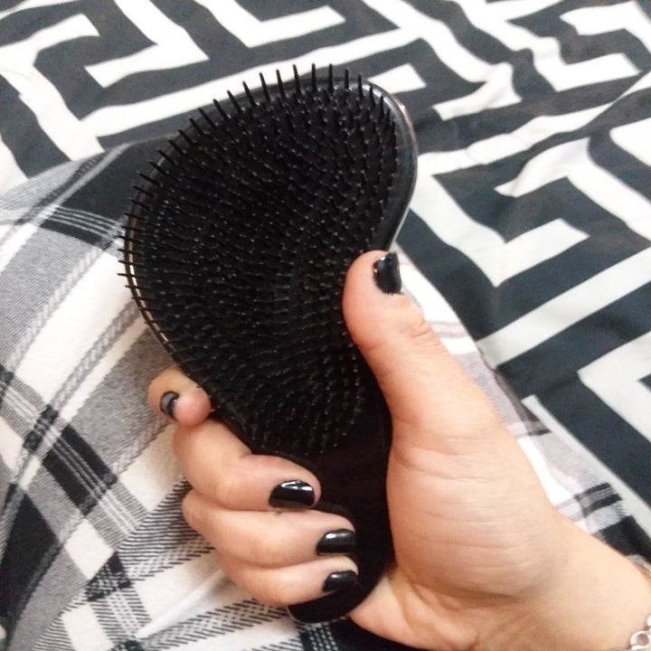 reviewer holding the curved brush