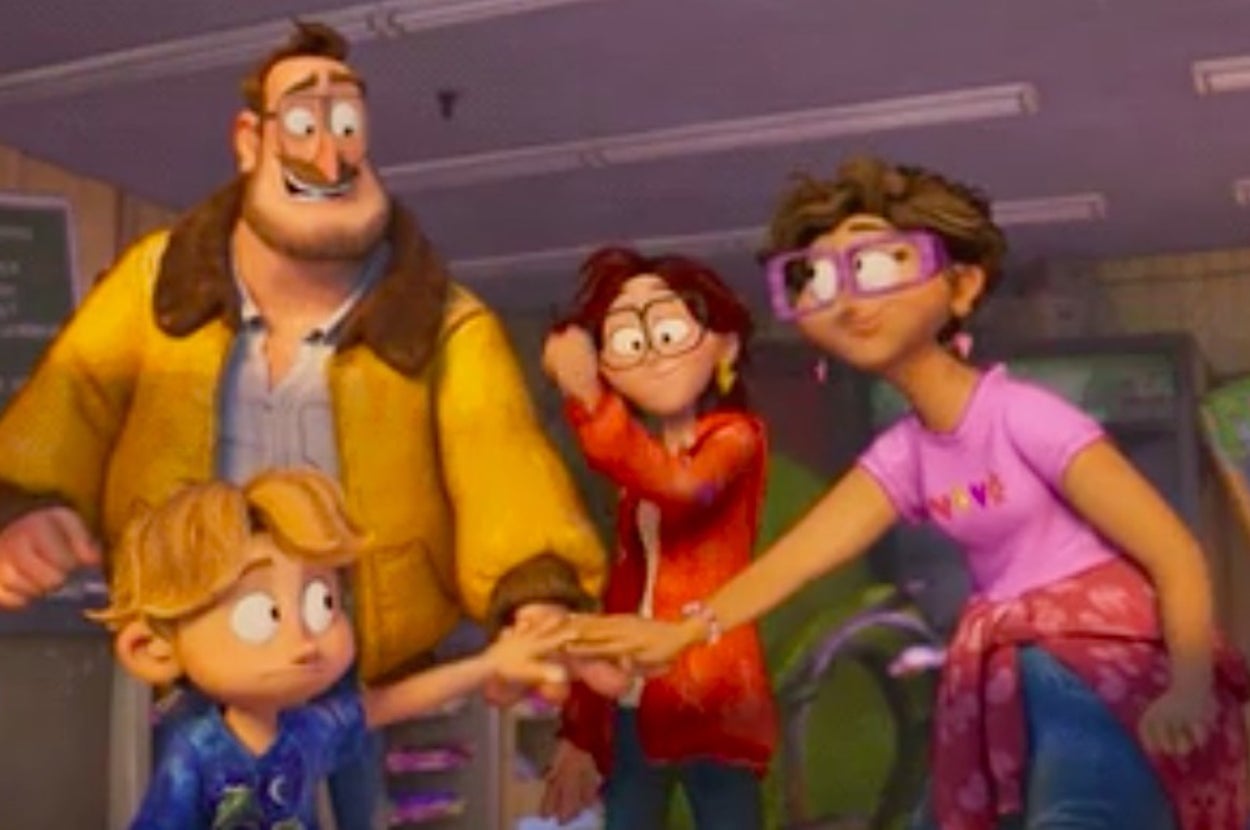 A family prepares to huddle up, placing one hand each in front of them. 