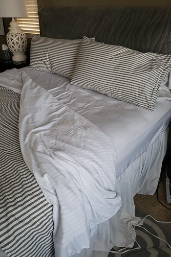 a reviewer photo of a bed with white bedsheets 