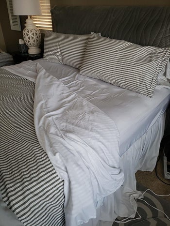 a reviewer photo of a bed with white bedsheets 