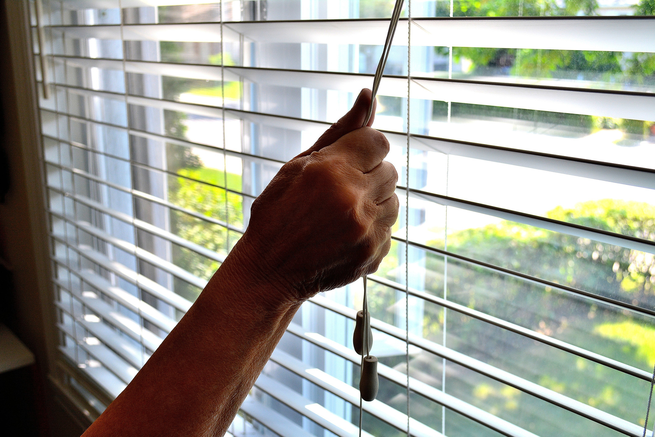 Person drawing the blinds on a bright day