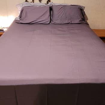 a reviewer photo of a bed with purple bed sheets 