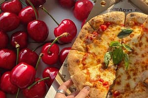 Image divided in half: one half is a picture of cherries and the the other half is a picture of a pizza. 