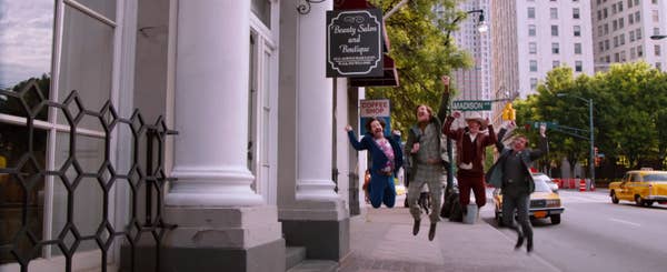 Brian Fantana, Ron Burgundy, Champ Kind, and Brick Tamland jumping happily on the sidewalk in "Anchorman 2 The Legend Continues"