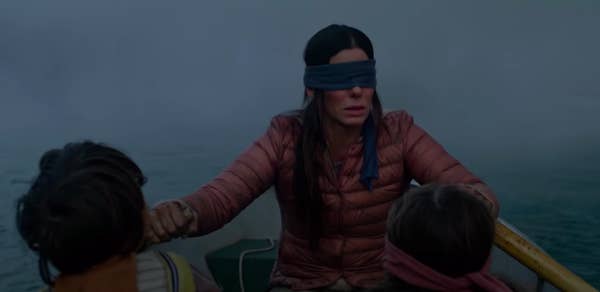 Malorie rowing a boat that her children are also in in "Bird Box"