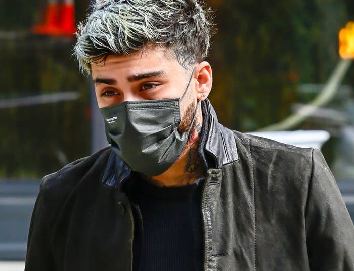 Zayn walking outside with a face mask on his face