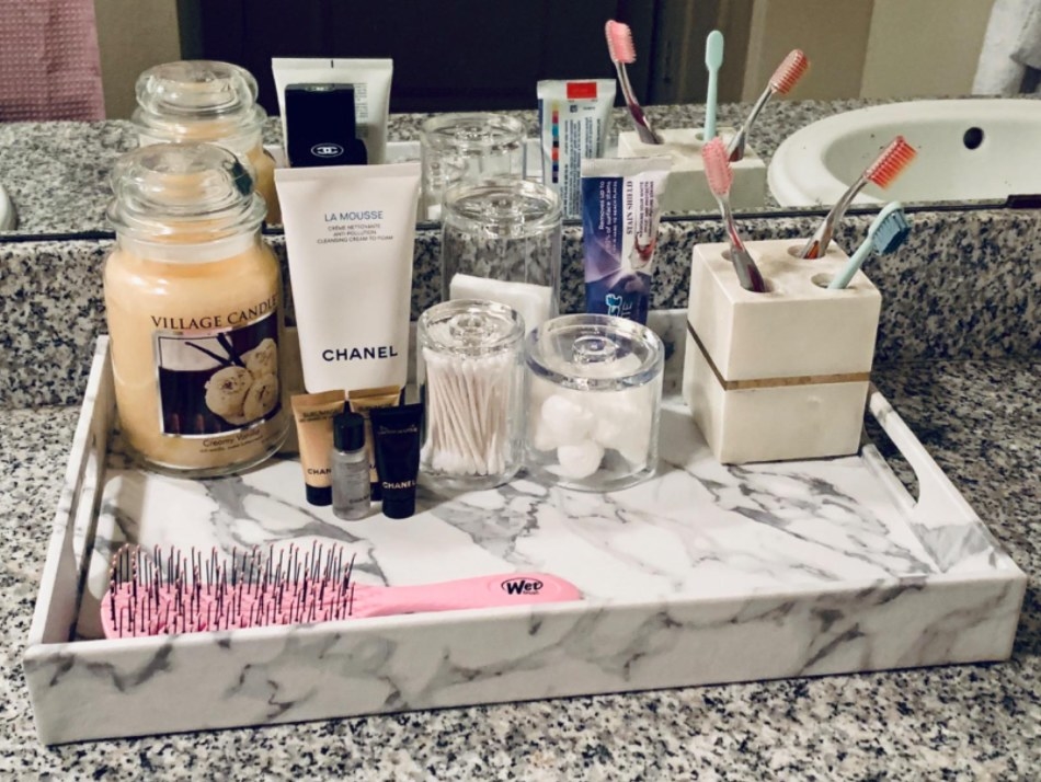 reviewer photo of the tray in their bathroom with skincare products and toiletries