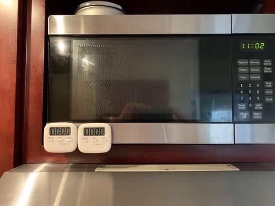 the two timers hanging on a microwave