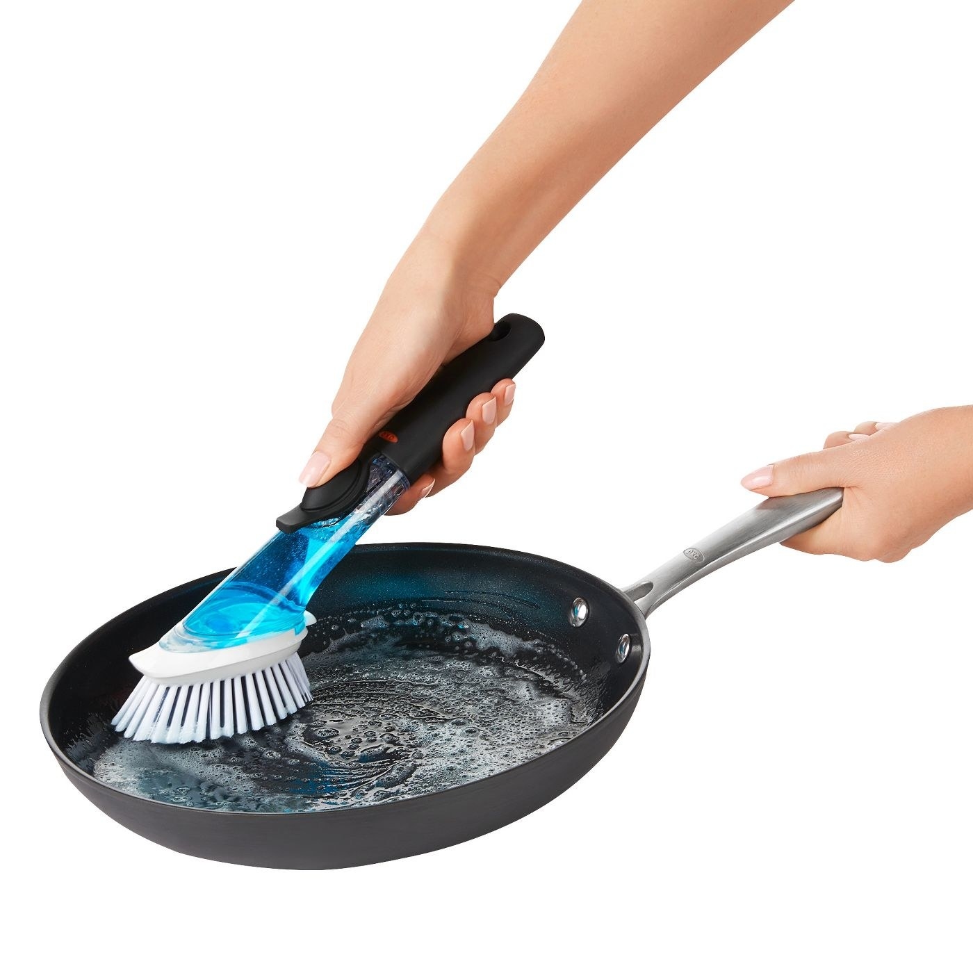 model using blue soap-filled brush to clean pan